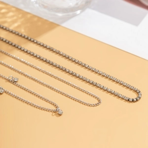 Détail de chaînes de corps argentées multicouches avec tennis chain et pendentif zircon