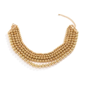 Detail view of a four-layer gold beaded necklace with graduated spheres and lobster clasp
