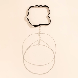Detailed macro view of silver thigh chain featuring sparkling rhinestones and black elastic band