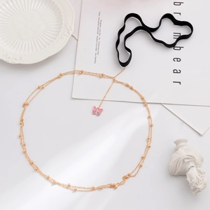 Detail of gold layered thigh chain with pink enamel butterfly charm and black elastic strap