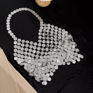 Macro shot of silver metal sequin halter top with mirror finish and mesh chainmail texture