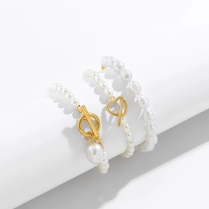 Detailed macro view of woven pearl bracelet set with gold OT clasp and heart charms