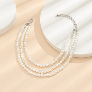 Détail d'une chevillère à trois rangs de perles avec fermoir réglable en argent poli