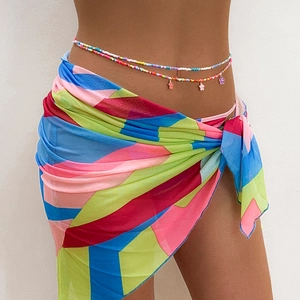 Colorful beaded waist chain belts with flower charms paired with a geometric beach sarong