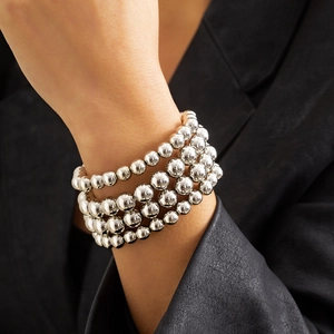 Silver bead chain bracelet set with four layers of polished metal spheres on a model