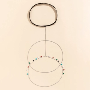 Detail of silver thigh chain featuring colorful heart charms and black elastic band