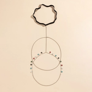 Detail of silver leg chain with colorful charms and elastic band for beach wear