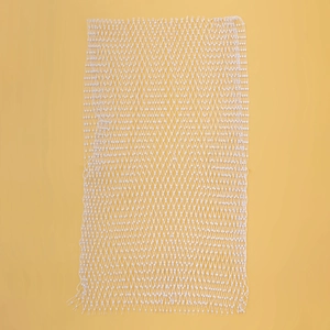 Détail de maille blanche avec perles fantaisie et motif en losange sur fond jaune vif