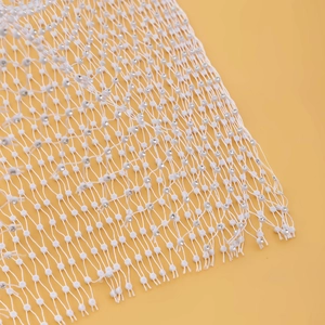 Détail du tissu en maille blanche avec strass brillants et bords à franges pour femme