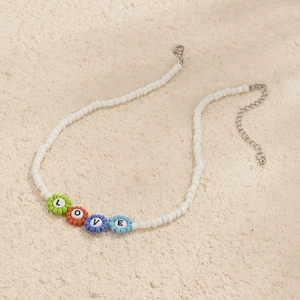 Detalle de collar de cuentas con flores de colores y colgantes de letras LOVE