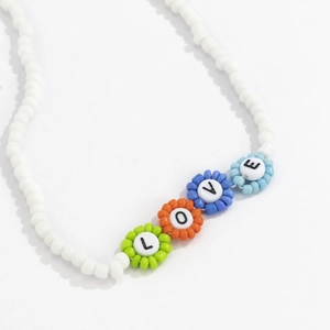 Detalle del collar de cuentas con colgantes florales coloridos que forman la palabra LOVE