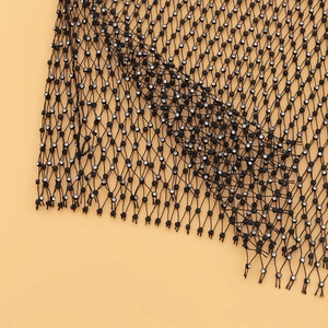 Détail du tissu en maille noire avec strass scintillants pour tenue de club sexy