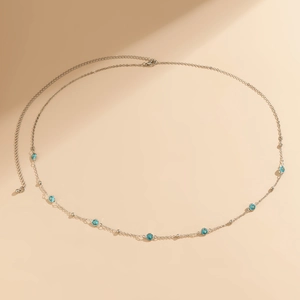 Detail of silver body chain with blue gems, lobster clasp, and adjustable extension