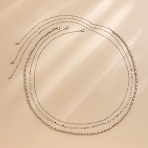 Détail d'une chaîne de taille argentée à plusieurs rangs avec perles et sequins métalliques