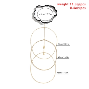Detailed view of layered gold leg chain with star and leaf pendants and elastic band