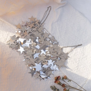 Close-up of silver star sequin body chain with fringe and disco style metal details