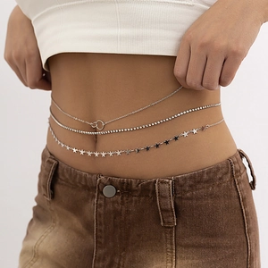 Détail d'une chaîne de corps argentée à trois couches avec strass et pendentifs étoiles