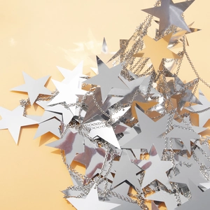 Detailed close-up of shiny silver star sequins on a delicate metal body chain