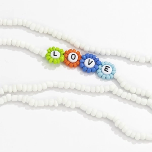 Detalle de cuentas florales coloridas con la palabra LOVE en collar de cuentas blancas