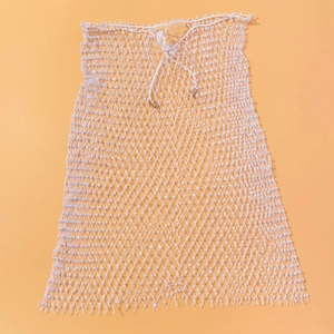Détail d'une jupe en maille blanche avec perles brillantes et taille à cordon réglable