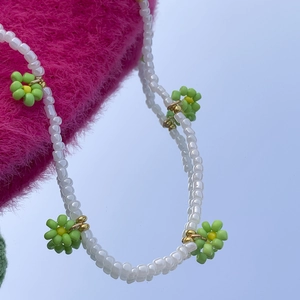 Dettaglio della collana di perle barocche con fiori di margherita di perline verdi