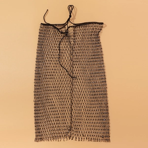 Détail d'une jupe en résille noire avec strass brillants et cordon de serrage à la taille