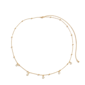 Dettaglio di una catena da corpo dorata con strass di cristallo e perline metalliche