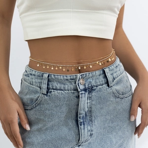 Détail d'une chaîne de taille dorée à plusieurs rangs avec strass et étoiles