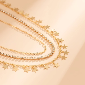 Vue détaillée de chaînes de corps dorées multicouches avec étoiles et strass brillants