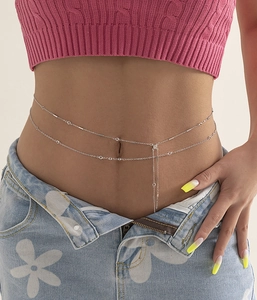 Detail of silver double-layered hip hop waist chain with crystals on blue jeans