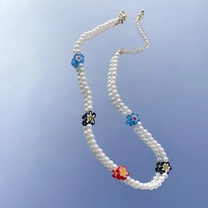 Dettaglio collana di perle con perline a margherita colorate e chiusura dorata