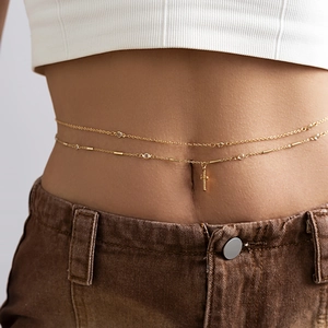 Double-layer gold waist chain with shimmering crystals and a cross pendant on a model