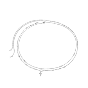Detail view of silver layered chain body jewelry with cross pendant and lobster clasp