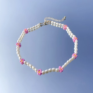 Dettaglio della collana di perle barocche con perline a margherita rosa e chiusura dorata