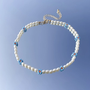 Dettaglio della collana a margherita con perline blu e perle barocche lucide