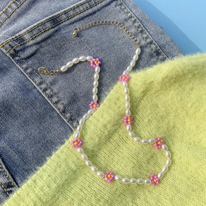 Dettaglio della collana di perle barocche e margherite con chiusura a moschettone dorata
