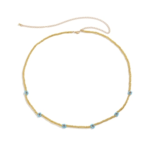 Close-up of handmade beaded waist chain with yellow beads and colorful daisy flower accents