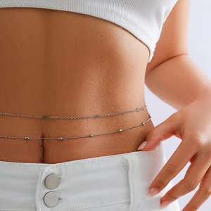 Close-up of double-layer metal waist chain with hollow flower charm on female model