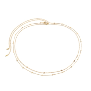 Detail of double-layer gold chain belt featuring hollow flower charms and beads