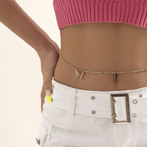 Detail of golden belly chain with crystal butterfly pendant on stylish model waist