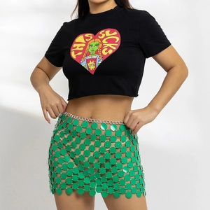 Detail eines grünen Pailletten-Bodychain-Rocks kombiniert mit schwarzem Crop-Top