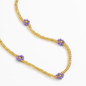 Detailed view of bohemian waist chain with colorful beads and purple daisy flowers