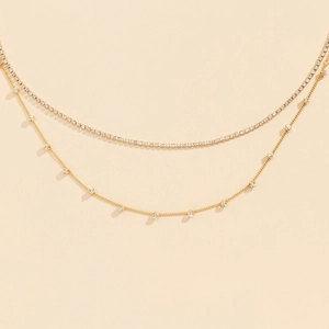Detailed macro view of gold-tone double-layer waist chain with crystal mesh and square pendants