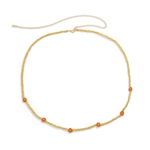 Detail of yellow handmade bead body chain with orange daisy flowers and golden clasp