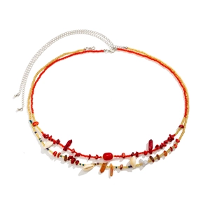Dettaglio catena in vita bohémien con perline rosse, conchiglie bianche e pietre colorate