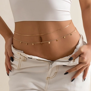 Detail of a double-layered gold waist chain featuring small round metallic pendants
