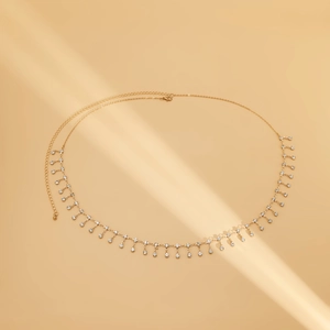 Detail of gold metal waist chain with rhinestone tassels and lobster clasp closure