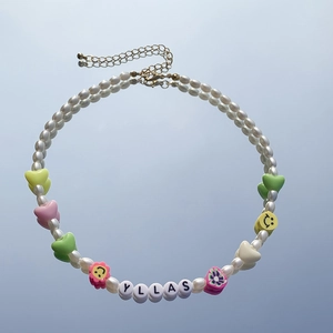 Dettaglio della collana di perle con cuori colorati e ciondoli a lettere SALLY