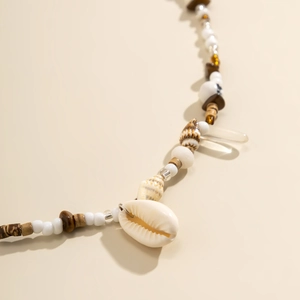 Dettaglio della catena in vita boho con conchiglie naturali e perline color terra