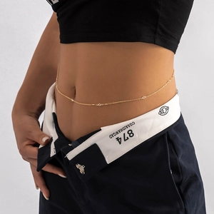Detailed close-up of a minimalist gold waist chain with delicate sparkling crystals